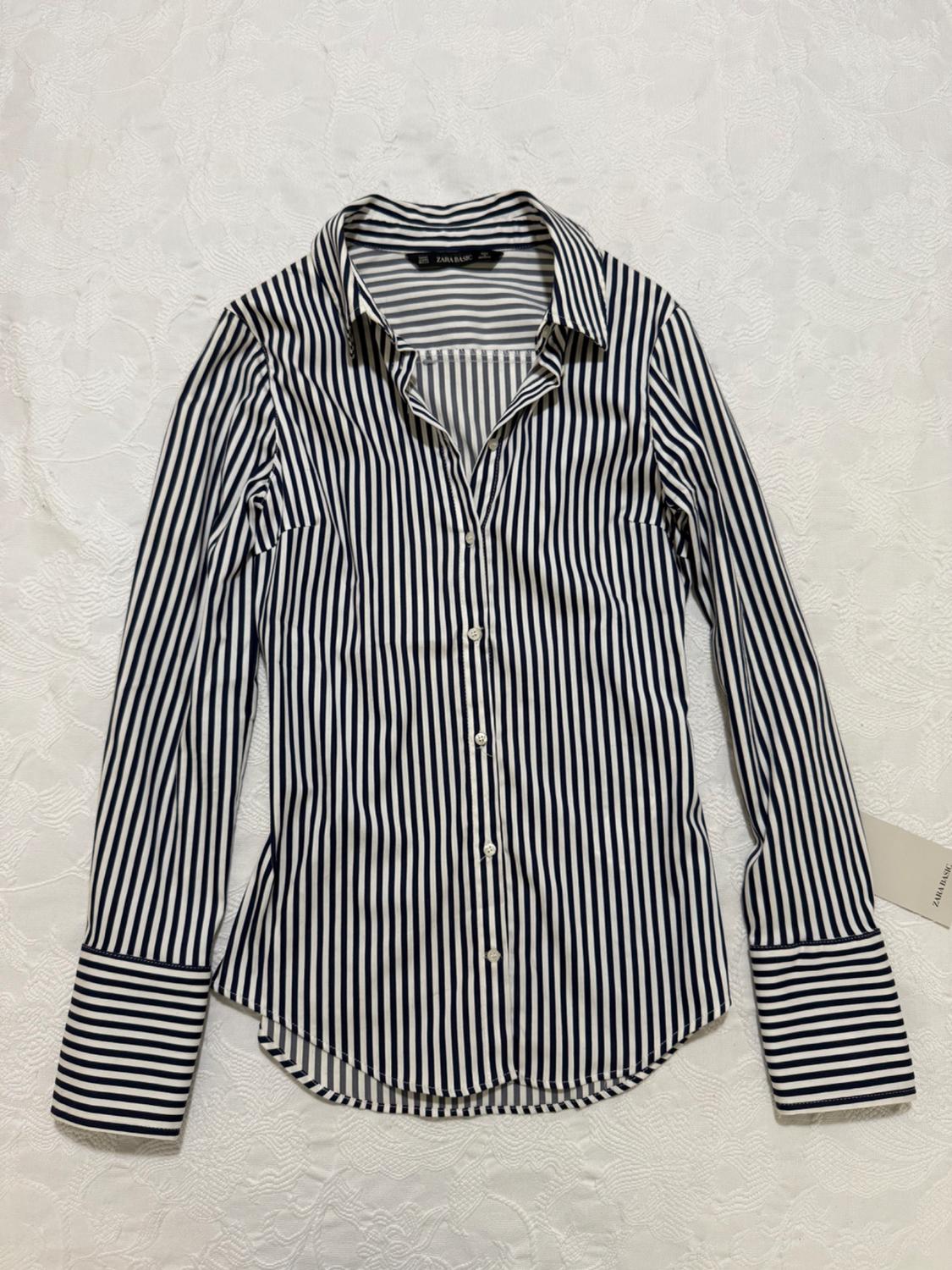 White and black vertical striped shirt with a wide collar and cuffs, on a white background. Visible label: "ZARA BASIC".