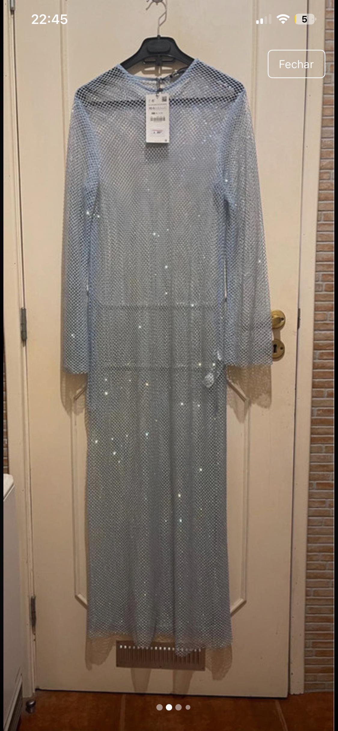 Sparkly mesh maxi dress hanging on a white door. Label visible on the collar. Time on screen: 22:45.