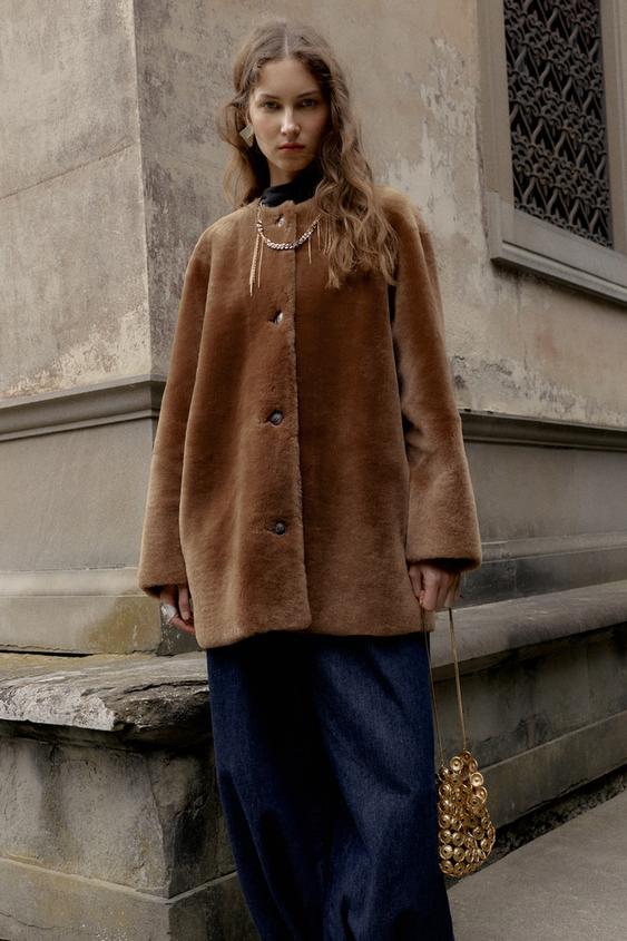 Hnd kabtov komplet s knoflky a tmav modrmi irokmi kalhotami. Viditeln mal zlat kabelka.