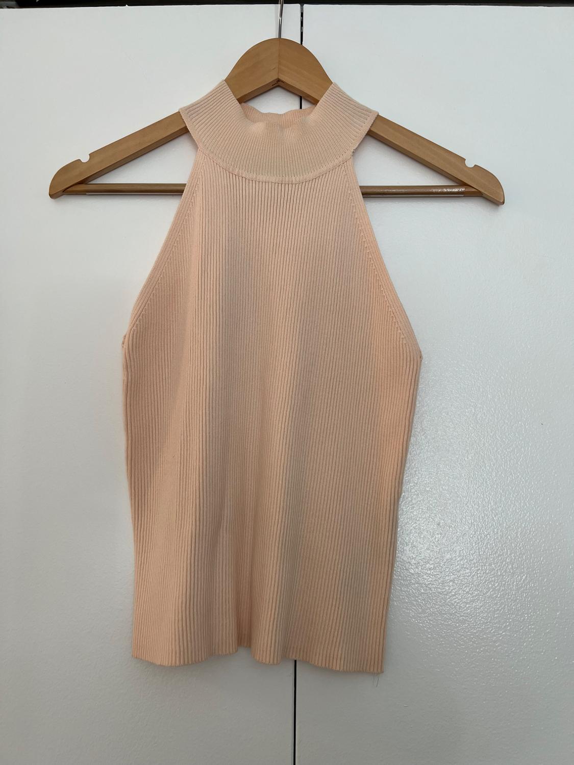 Front view of a beige sleeveless high-neck top on a hanger.