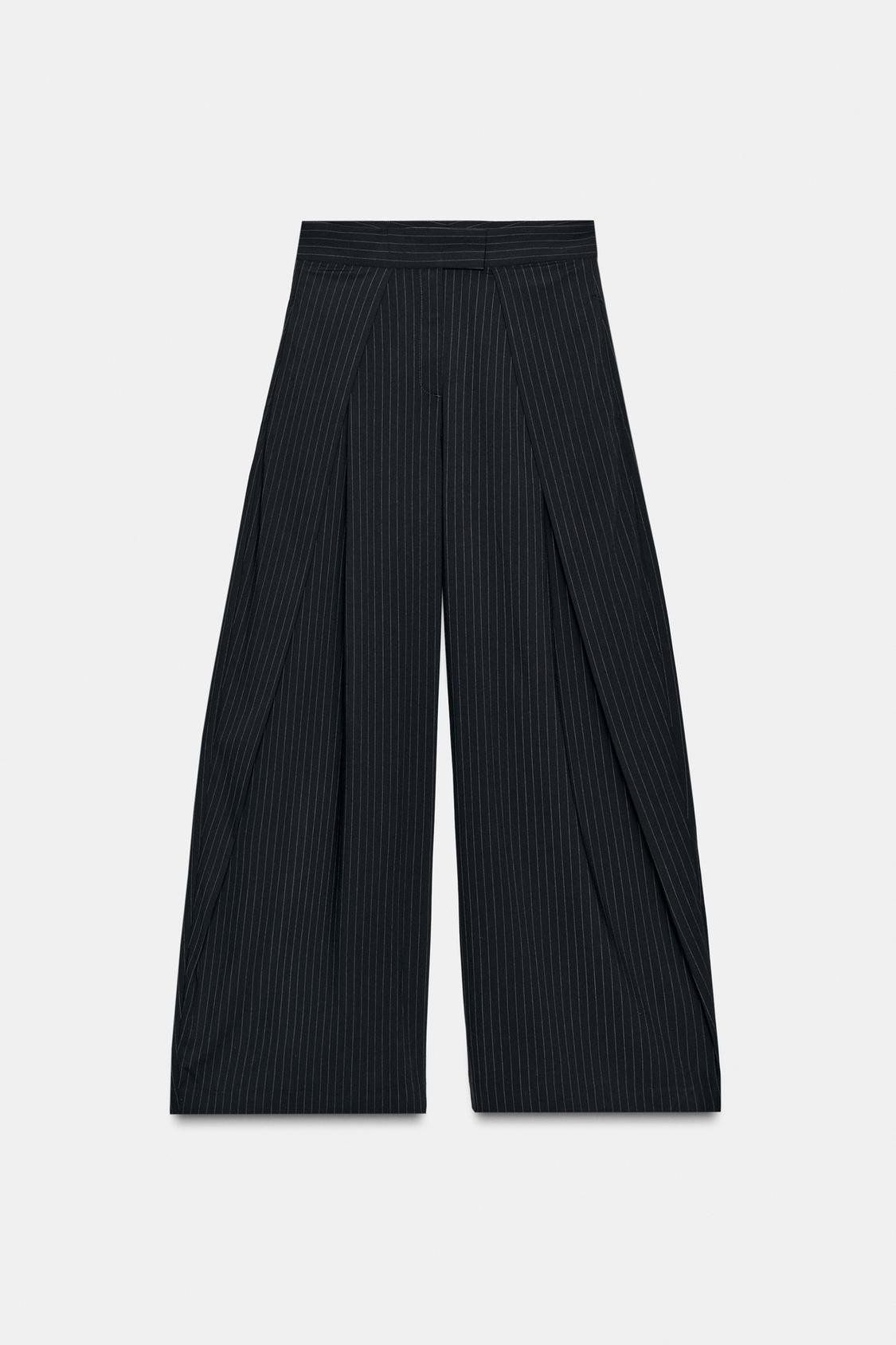 Front view of wide-leg trousers with pinstripes, mid-rise, belted waist with belt loops and side pockets.