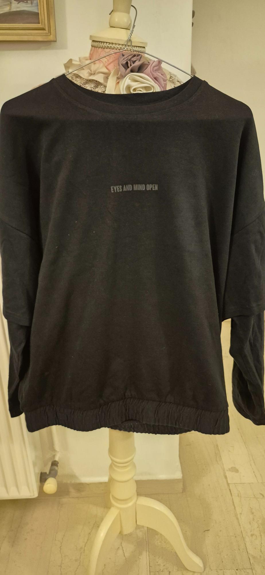 Black sweatshirt with "EYES AND MIND OPEN" text on the chest, hanging on a mannequin decorated with fabric flowers.