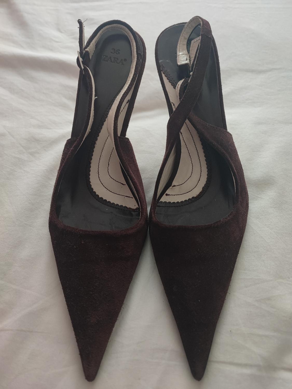 Dark brown high-heeled shoes with pointed toes and crossed straps, on a white background. Visible text: "36 ZARA".