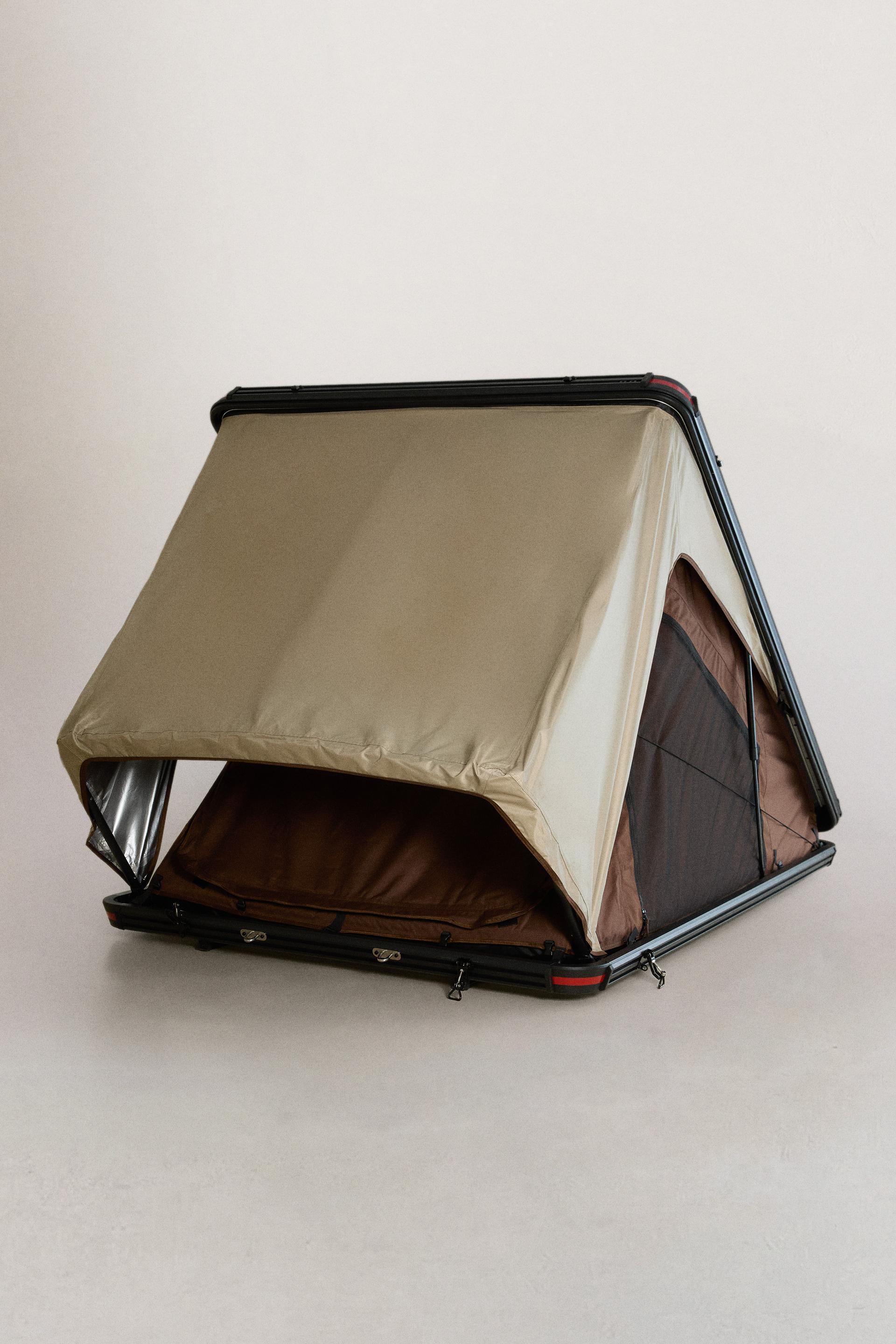 Front view of a beige rooftop tent with a raised frame, front opening, black base with latches, and dark side window.