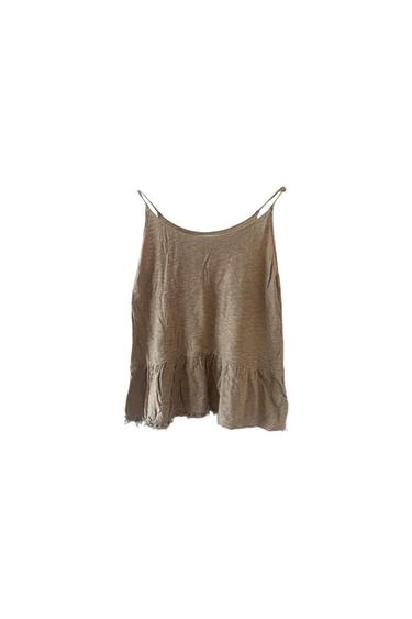 Beige camisole top with a frilled hem on a white background.