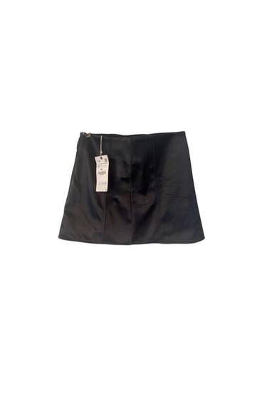 Front view of a black skirt with a visible tag.