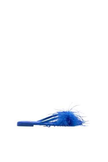Side view of a blue sandal with feather detail on the upper.