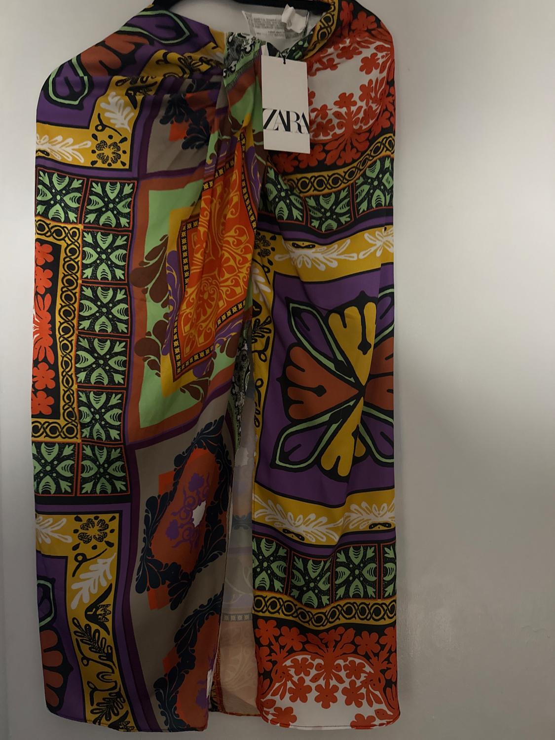 Hanging skirt with a colorful print of geometric and floral patterns in orange, green, purple, and yellow tones. Visible tag: ZARA.
