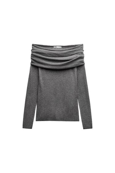 Long-sleeved gray sweater with a wide, draped neckline. Visible tag on the inside of the neck. White background.