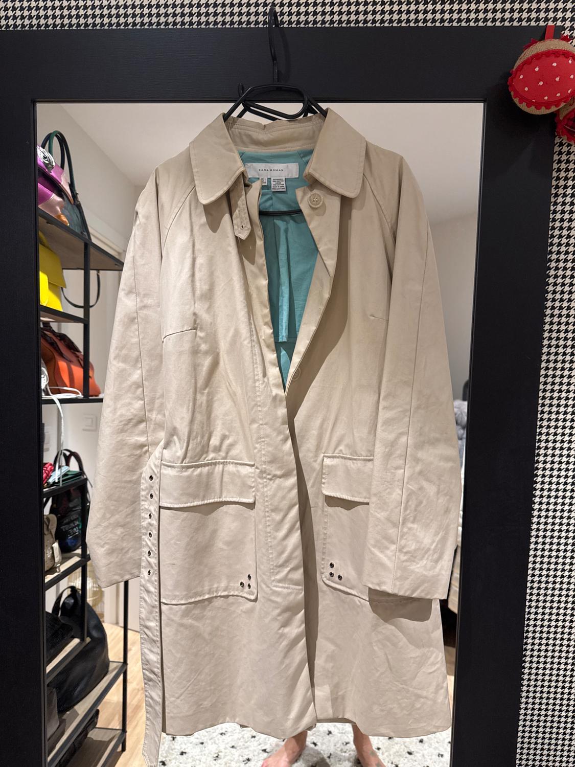 Front view of a beige coat with front pockets and a large lapel.