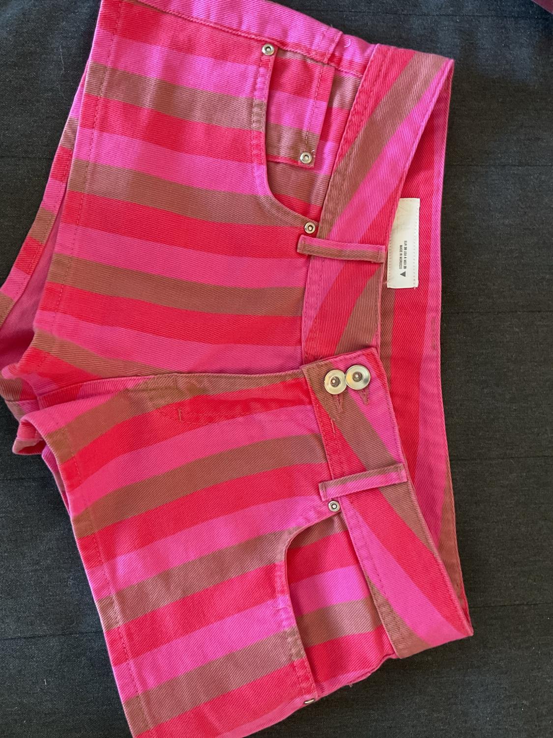 Pink and brown striped shorts with two buttons on a grey background. Text: EUR 38 USA 6 MEX 28 MADE IN MOROCCO.