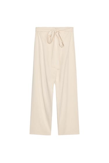 Front view of beige trousers with tie waist, straight leg and ankle length.