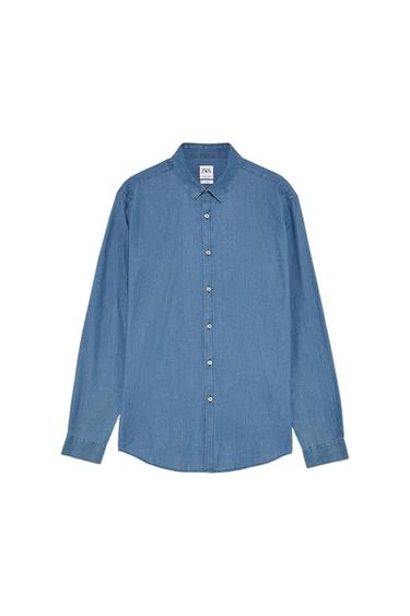 Blue denim shirt with front buttons and classic collar. Visible label on the inside of the collar. White background.