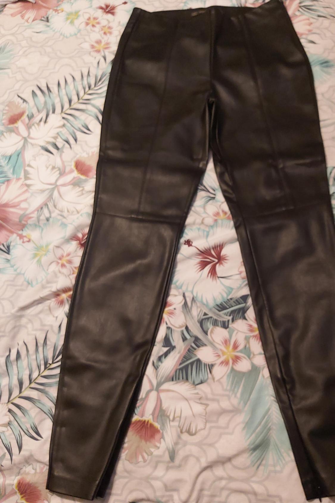 Front view of black trousers with decorative stitching.