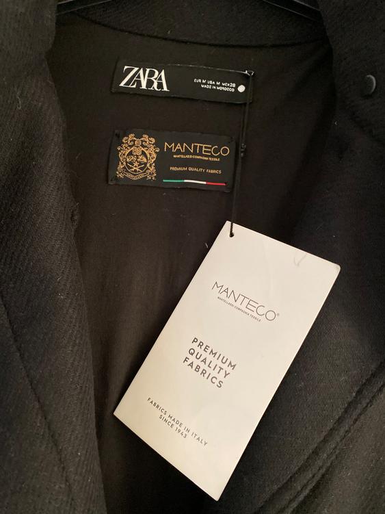 Black jacket label with Zara and Manteco logos. Visible text: "Premium Quality Fabrics", "Fabrics Made in Italy Since 1943".