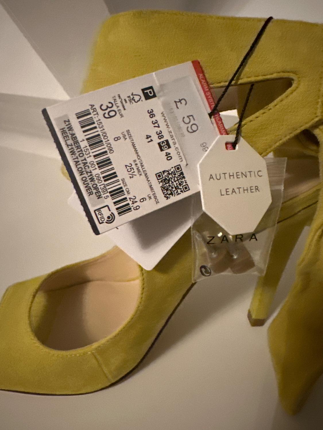Yellow high-heeled shoe with a £59 price tag and an "AUTHENTIC LEATHER" label. ZARA brand visible on the packaging.