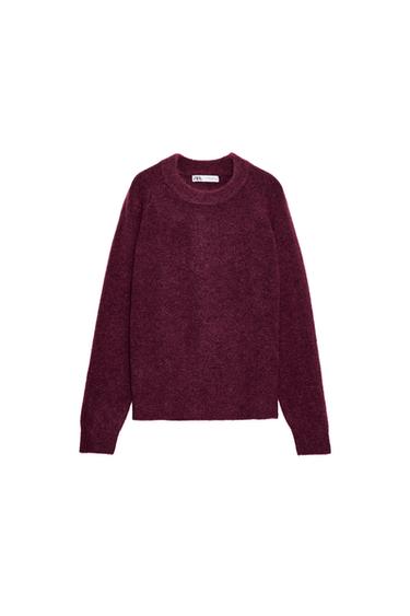 Front view of a pink knitted jumper with a round neck and long sleeves.