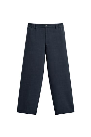 Front view of relaxed fit navy pants with adjustable waist, front pockets, patch back pocket, zip and button closure.