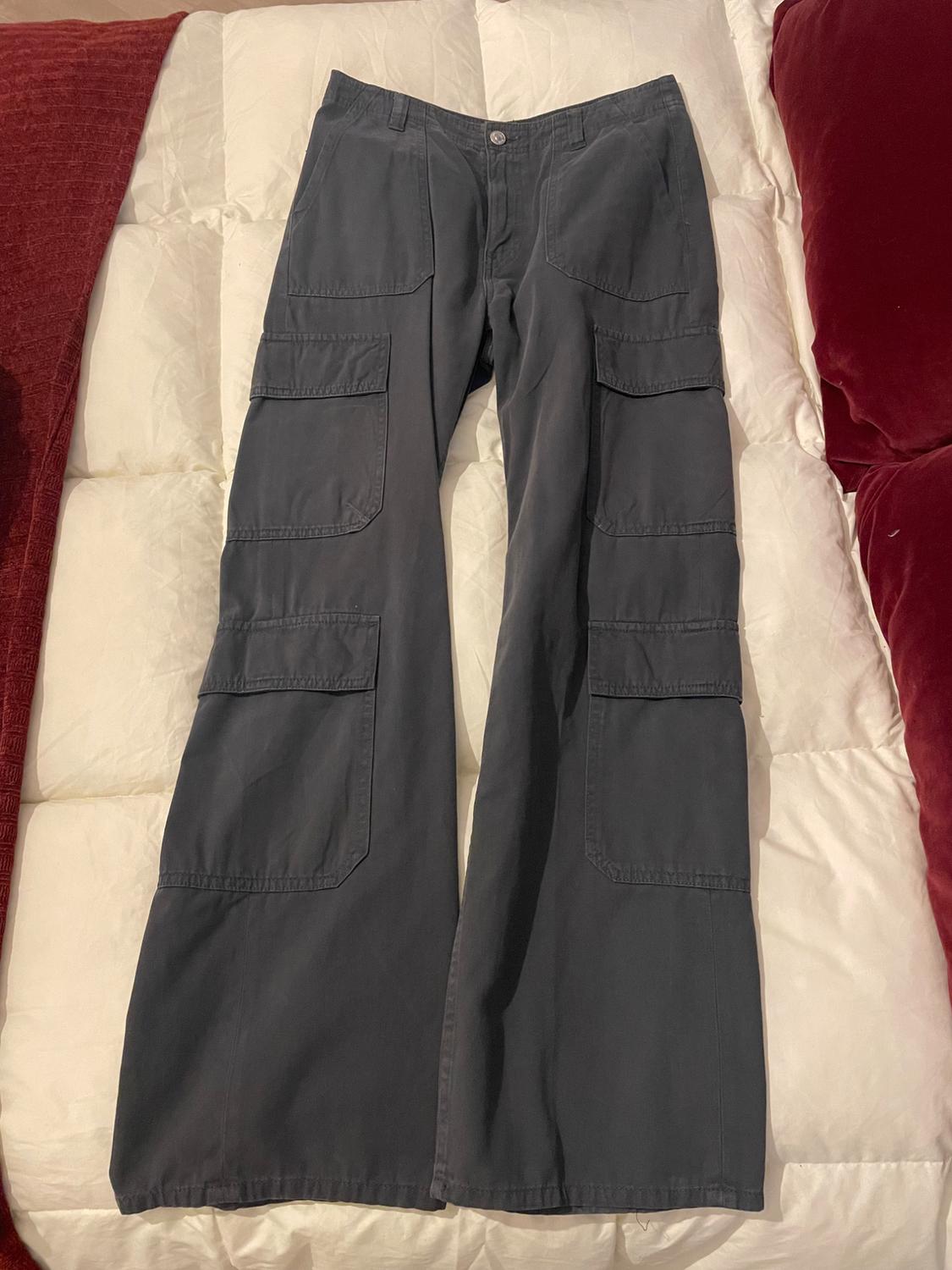 Front view of grey wide-leg trousers with side cargo pockets.