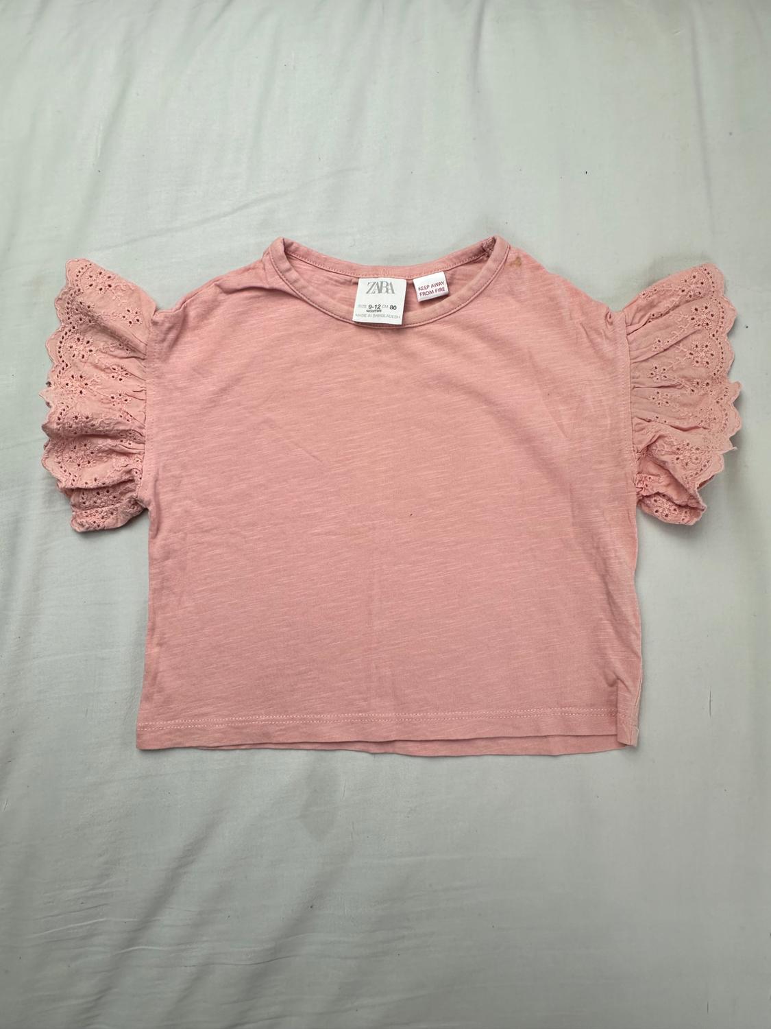 Pink baby Zara T-shirt with ruffled sleeves and eyelet details. Visible tags with text Zara and Keep away from fire.