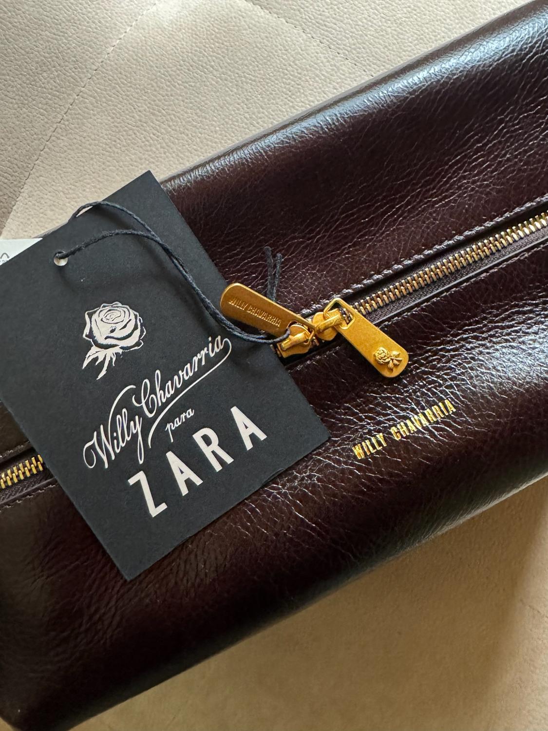 Brown bag with a gold zip. Black label with the text Willy Chavarria for ZARA and WILLY CHAVARRIA printed in gold.