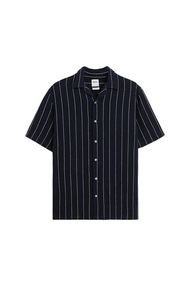Short-sleeved shirt with white vertical stripes on a black background. Classic collar and front buttons. Visible tag: ZARA.