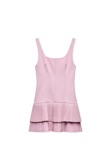 Front view of a pink dress with straps and a double-layered pleated skirt.