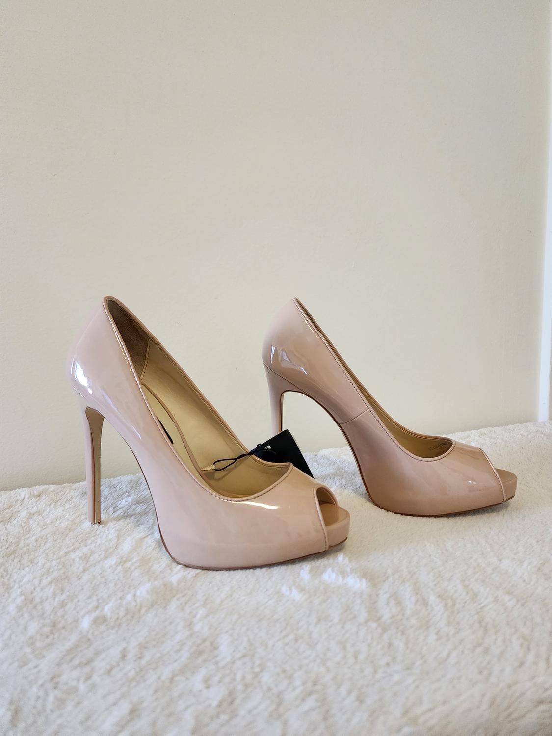 Nude high-heeled shoes with a peep-toe design.