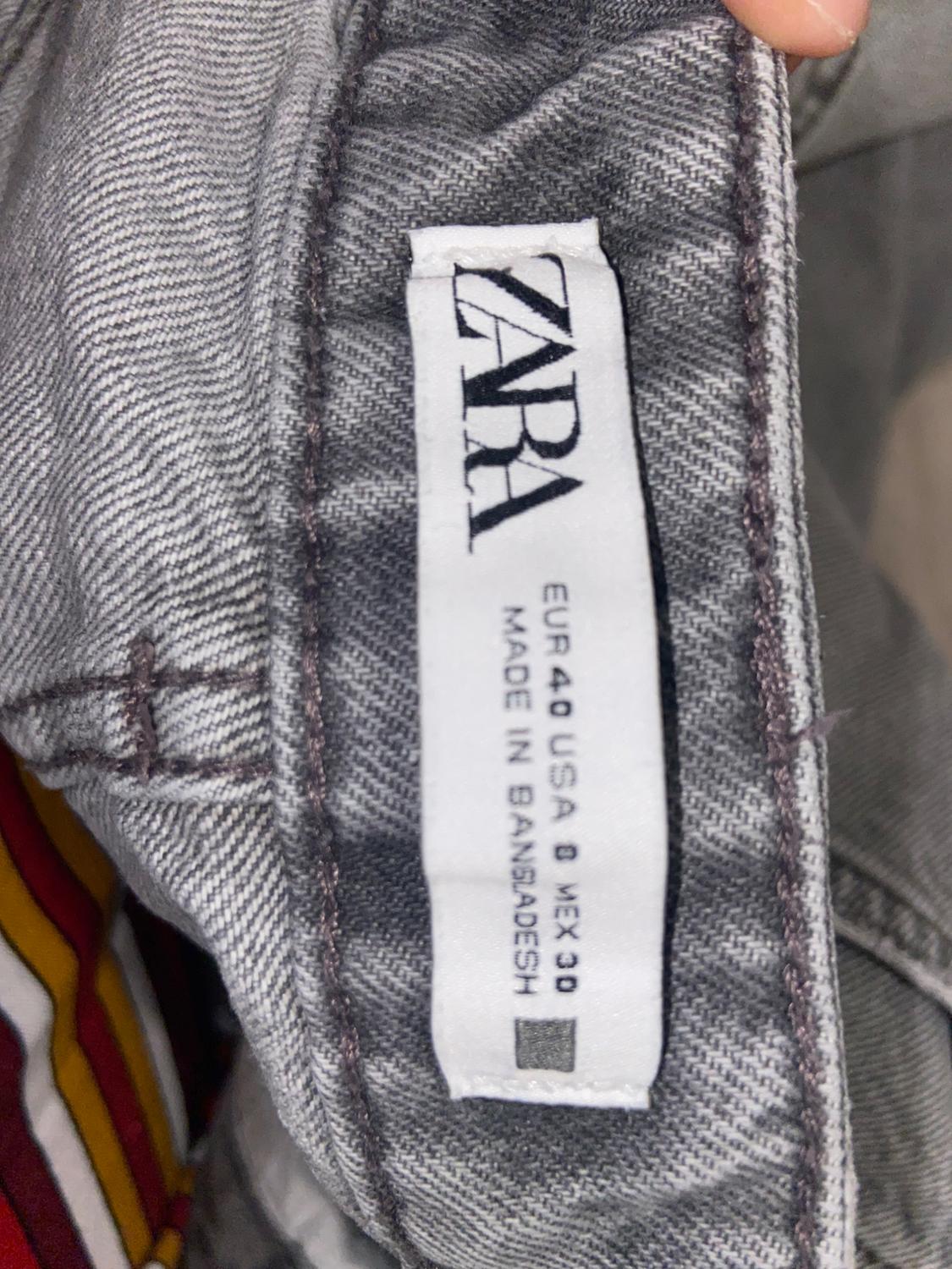 Grey clothing label with text "ZARA, EUR 40 USA 8 MEX 30, MADE IN BANGLADESH" visible on the inside of a garment.