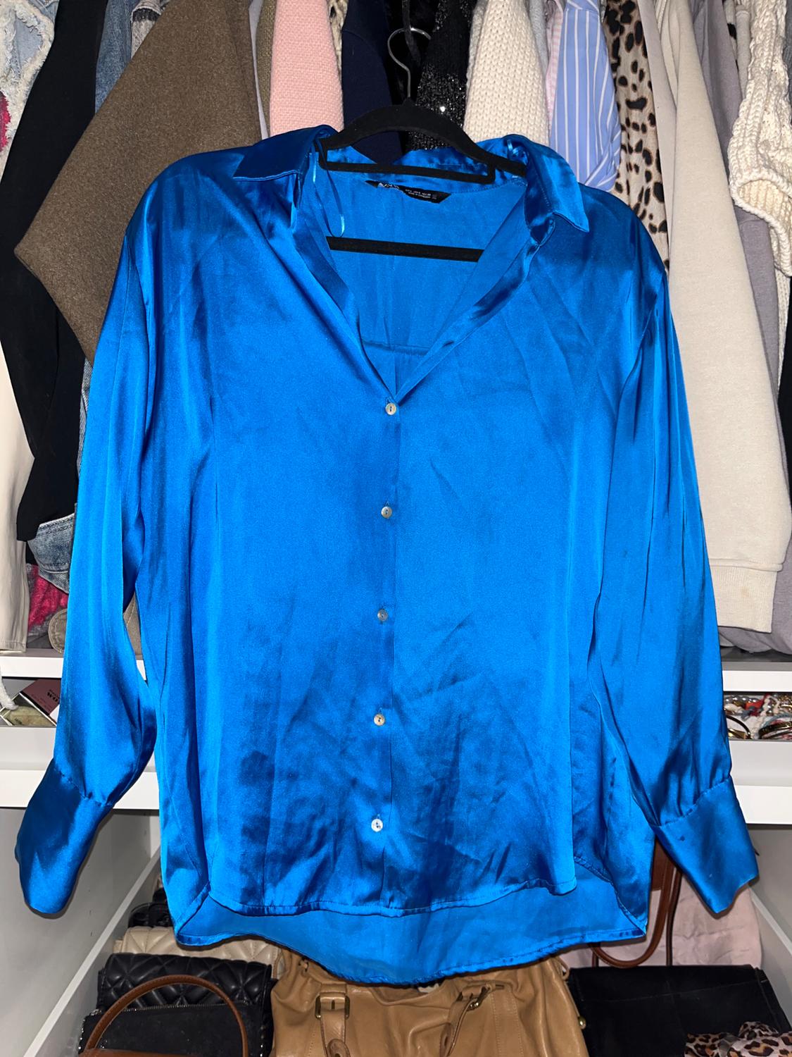 Front view of a bright blue button-up shirt with a classic collar.