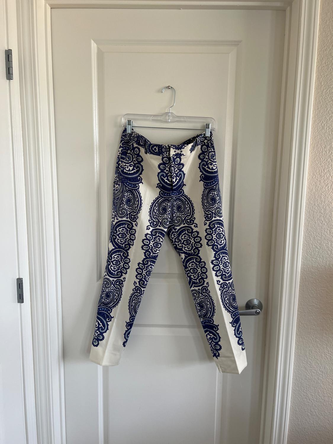 Front view of white trousers with an ornamental blue print.