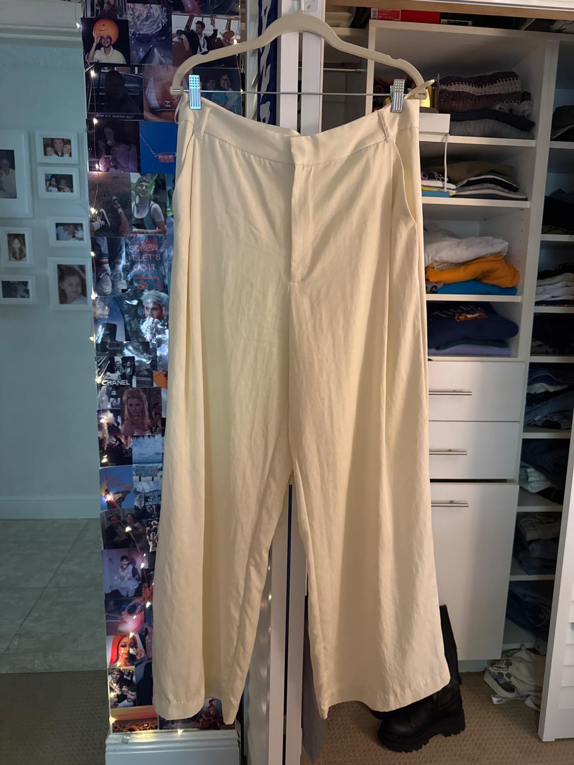 Front view of cream-coloured trousers with a high waist and wide leg.