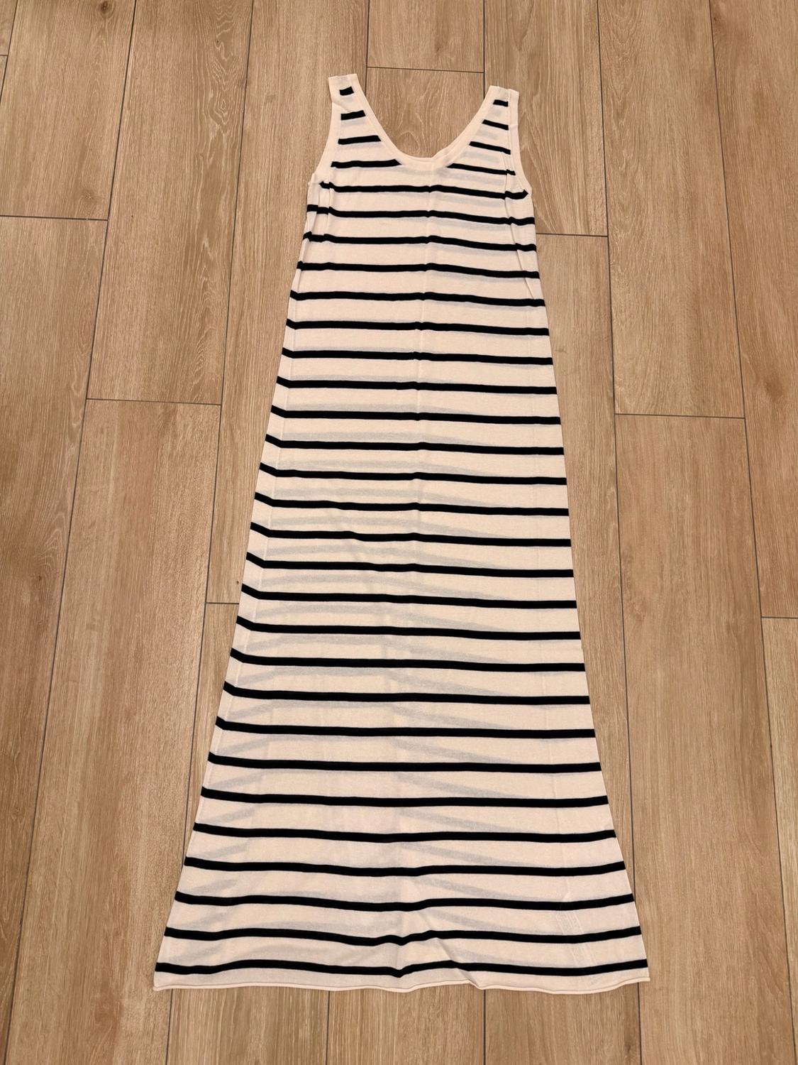 Long strappy dress with horizontal black and white stripes, laid out on a wooden floor.