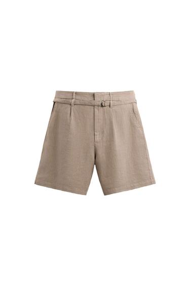 Front view of beige shorts with belt and side pockets.