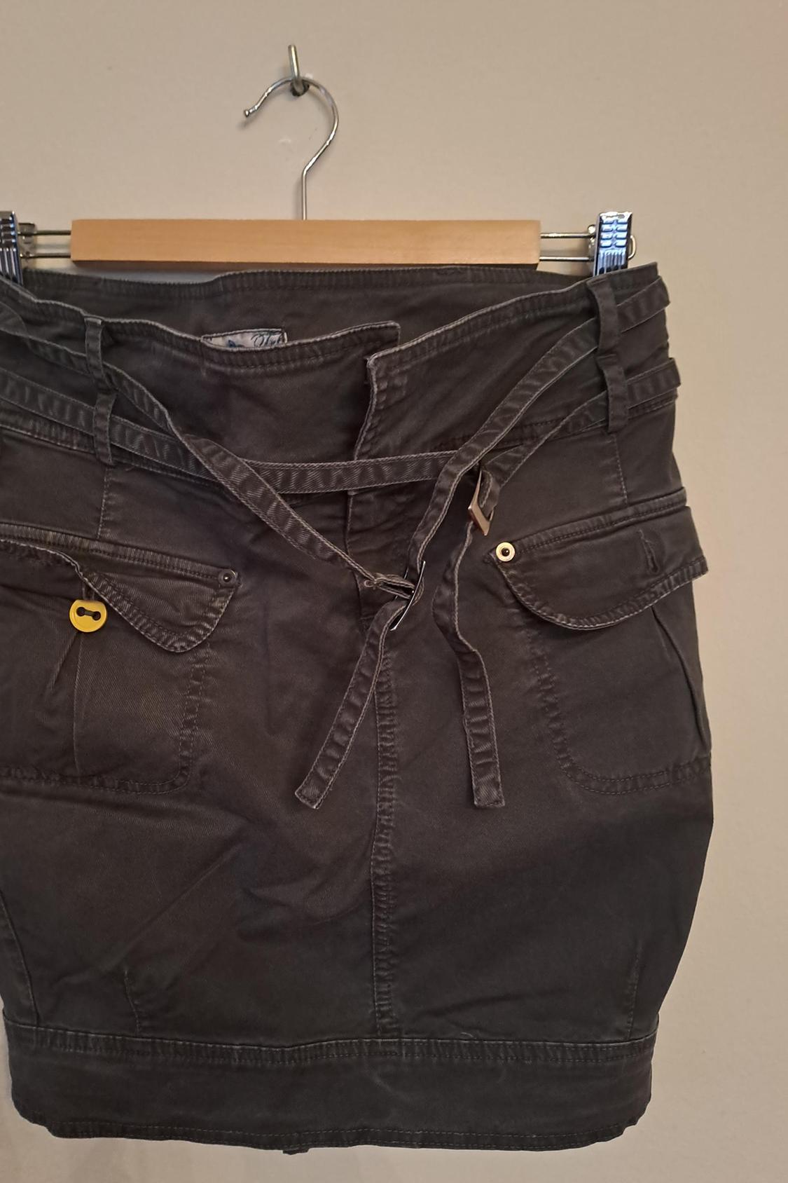 Front view of black skirt with side pockets and adjustable belt.