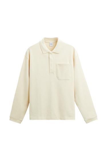 Front view of beige polo shirt with front pocket and classic collar.