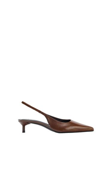 Brown slingback shoe with a low heel and pointed toe. Side view on a white background in a minimalist composition.