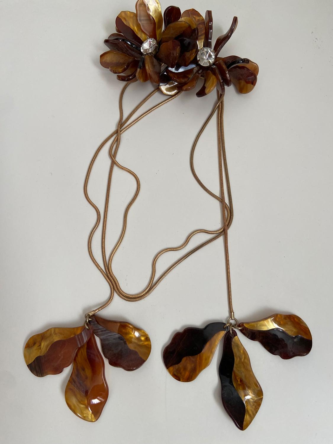 Brown and gold petal pendant necklace, embellished with crystals, on a white background.