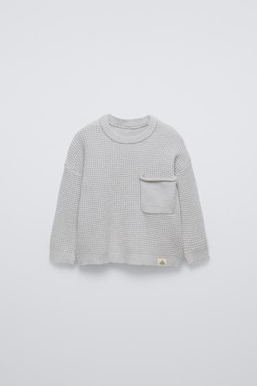 Zara Sweater with round neck and long sleeves with cuffs. Back button closure. Patch pocket at chest. Label appliqué at hem. - Light gray