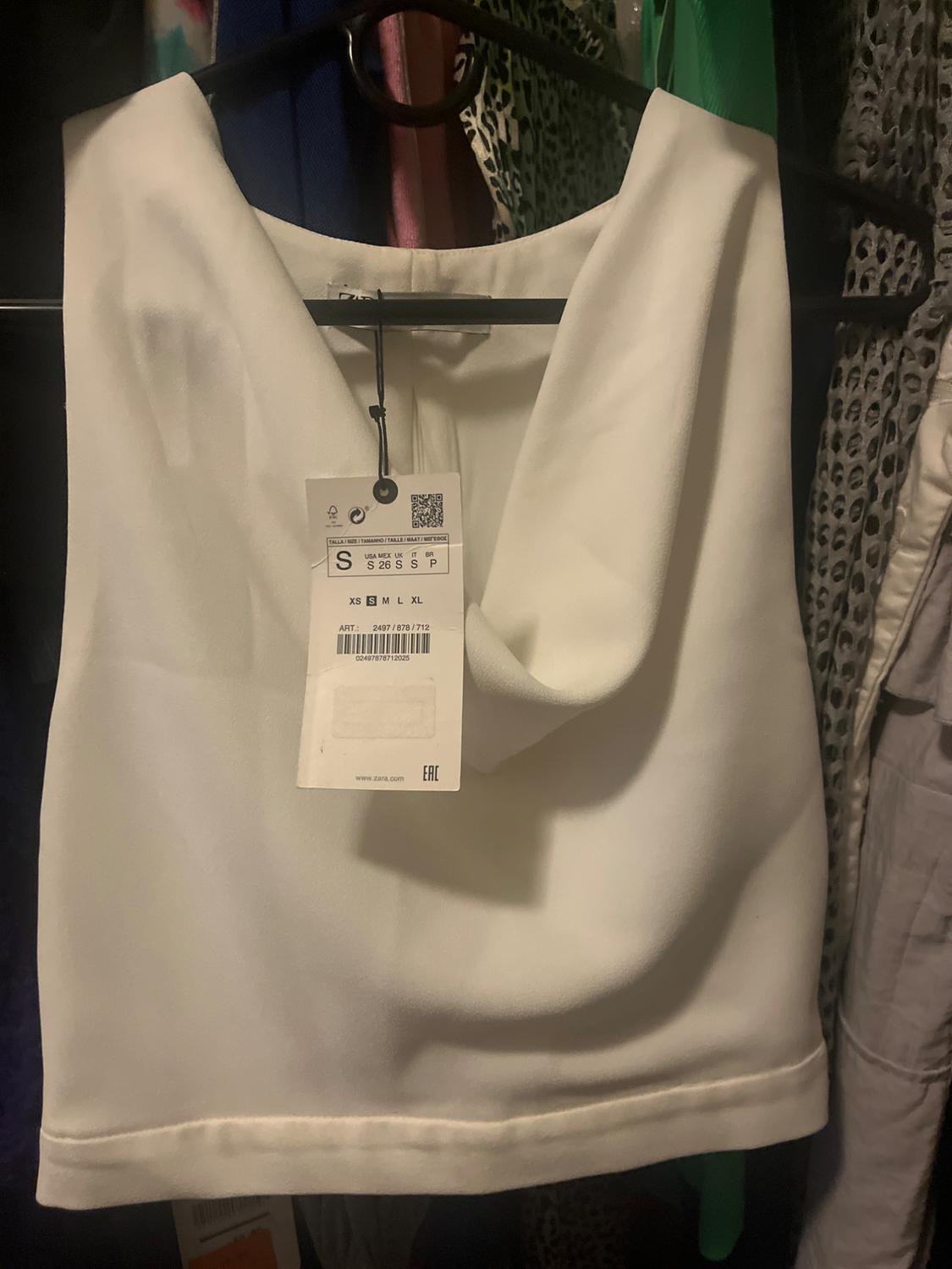 Draped white top on hanger. Label: S USA MEX UK IT BR S 26 S S P XS S M L XL ART.: 2497/878/712 02497878712025 EAC.