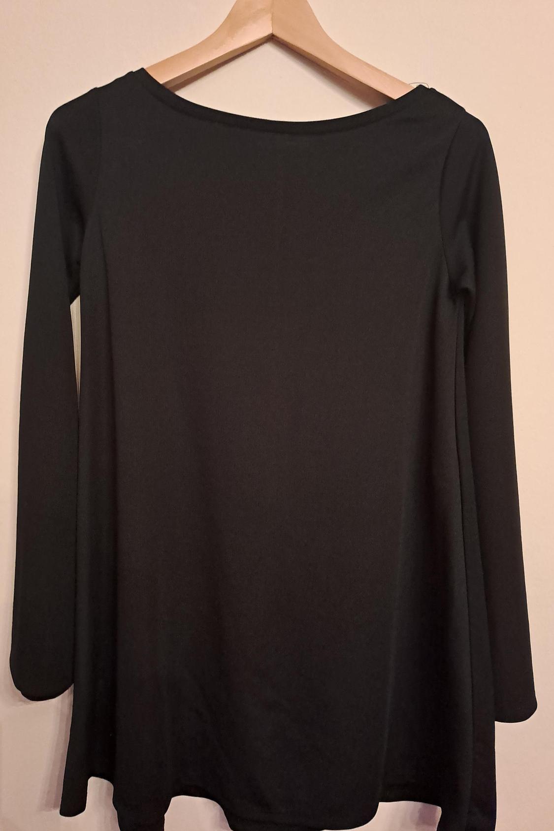 Rear view of a black long-sleeved blouse on a hanger.