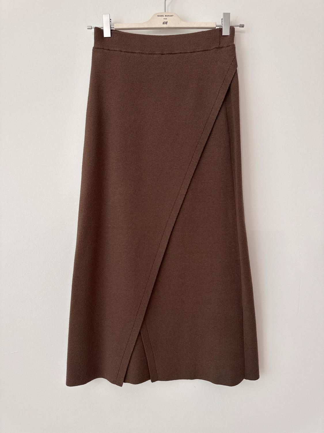 Brown asymmetrical skirt hanging on a wooden hanger with the "ISABEL MARANT" and "H&M" brand visible at the top.