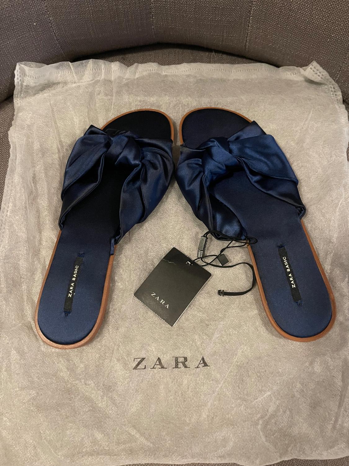 Navy flat sandals with knot on white dust bag. Text: ZARA BASIC on insoles, ZARA on label and dust bag.