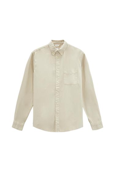Beige long-sleeved shirt with a button-down collar, front button closure, and a chest pocket, on a white background.