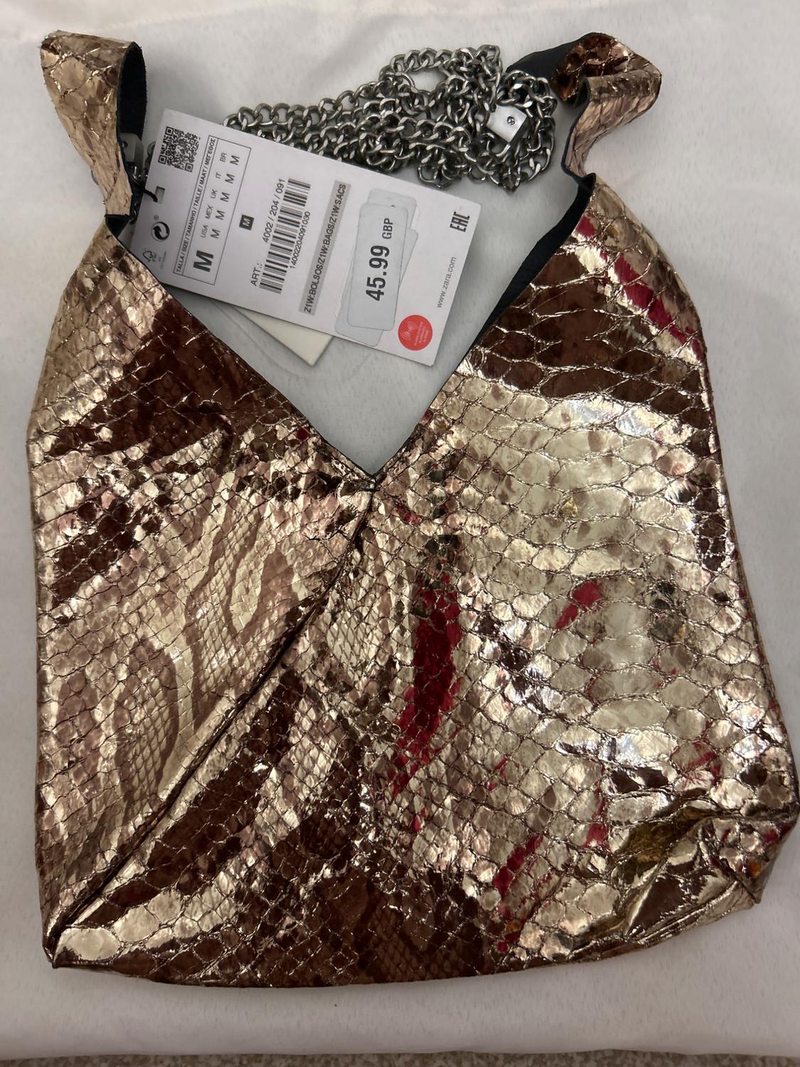 Metallic handbag with snakeskin texture, silver chain, and price tag of £45.99 on a white background.