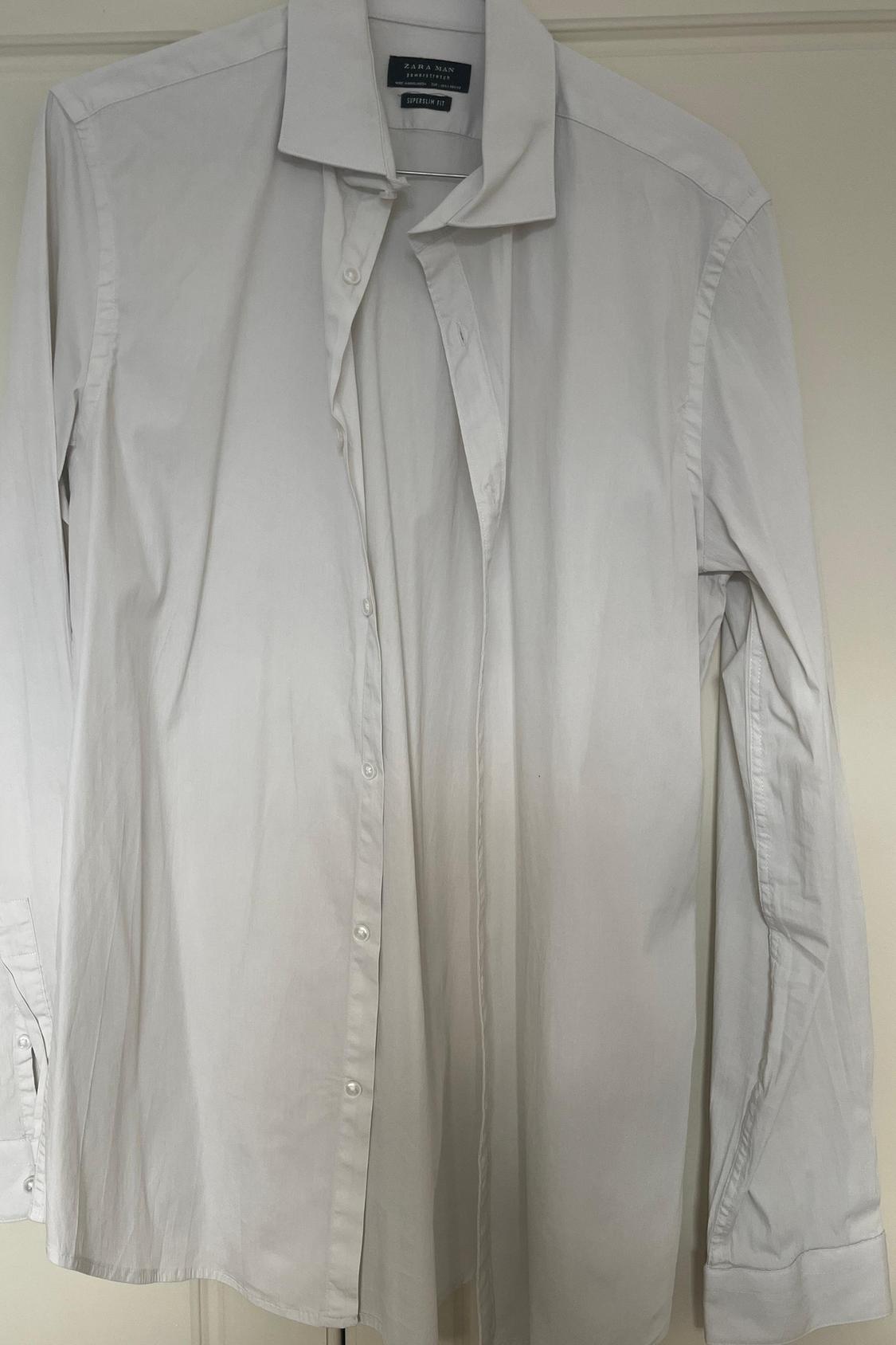 Front view of a white shirt with buttons and a classic collar.