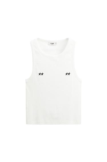 White sleeveless t-shirt with two black stars on the chest. Visible inner label with "Zara" text.