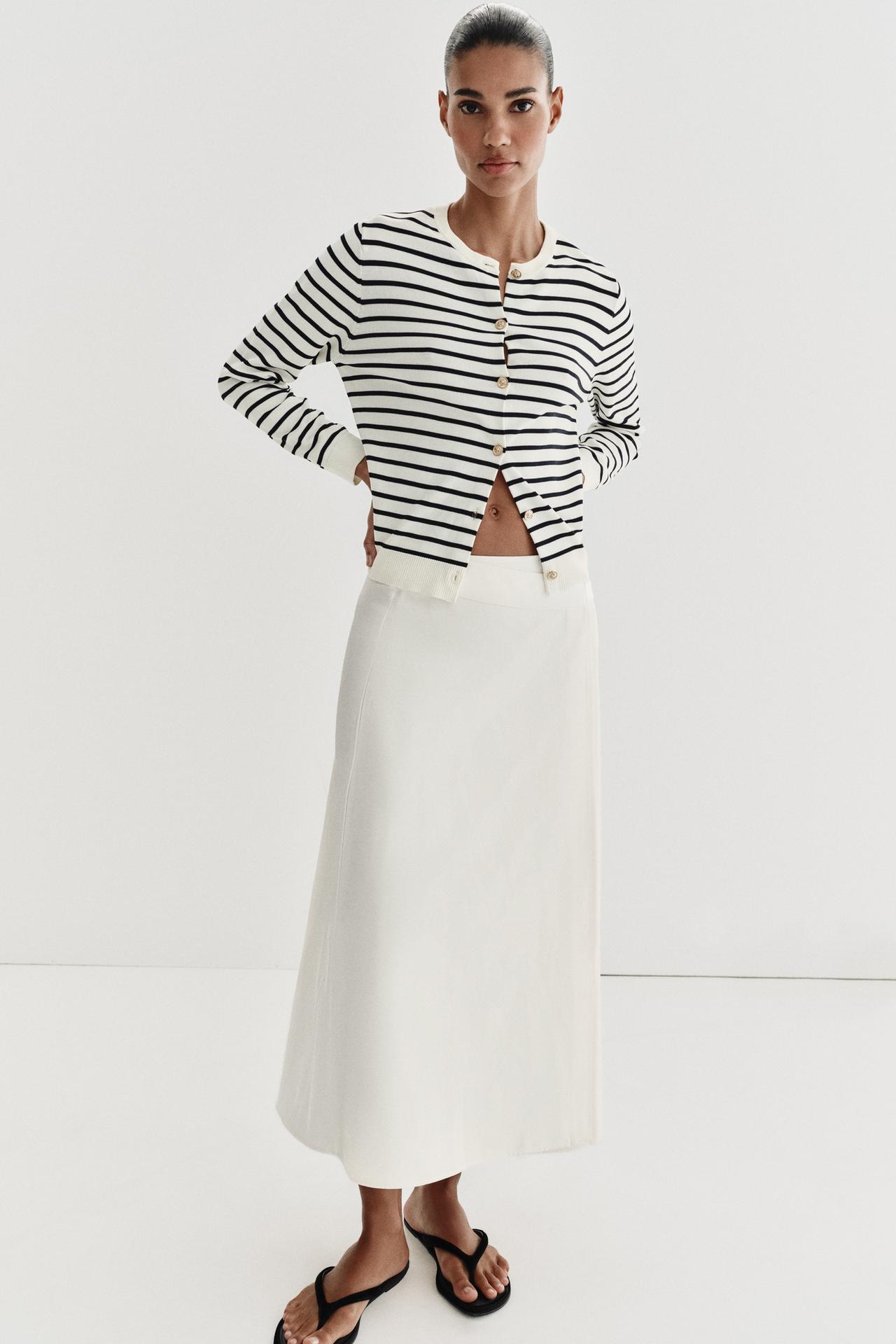 Striped crew-neck button-up jacket set with a white long skirt and black sandals.