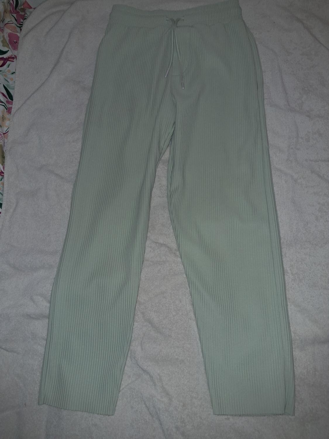 Light green pleated wide-leg trousers with an elasticated drawstring waist, on a white background.