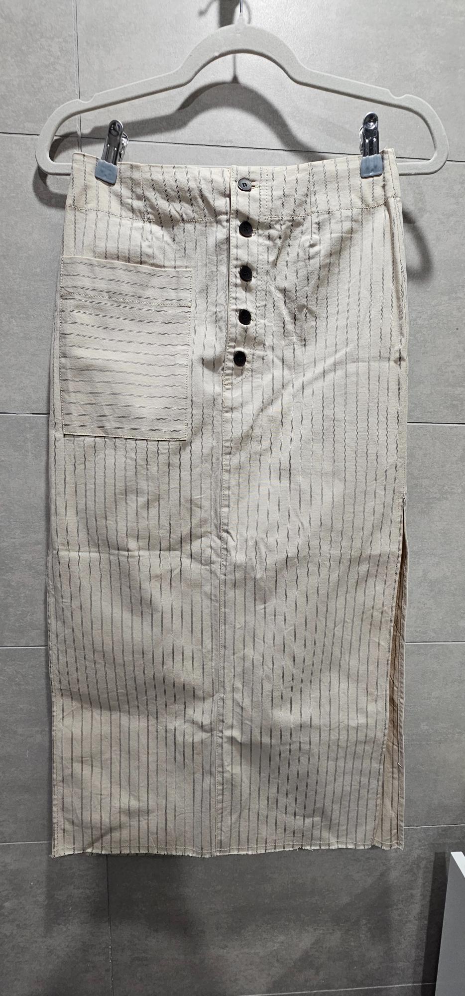 Beige midi skirt with vertical stripes, dark front buttons, patch pocket and frayed hem, hanging on a hanger.